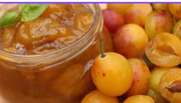 Pot de confiture de mirabelles avec cuillère, entouré de mirabelle frais et tranches sur fond coloré.