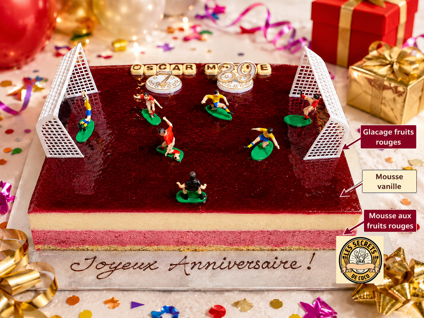 Gâteau d’anniversaire rouge et blanc avec figurines de football, confettis, cadeaux et inscriptions gourmandes.