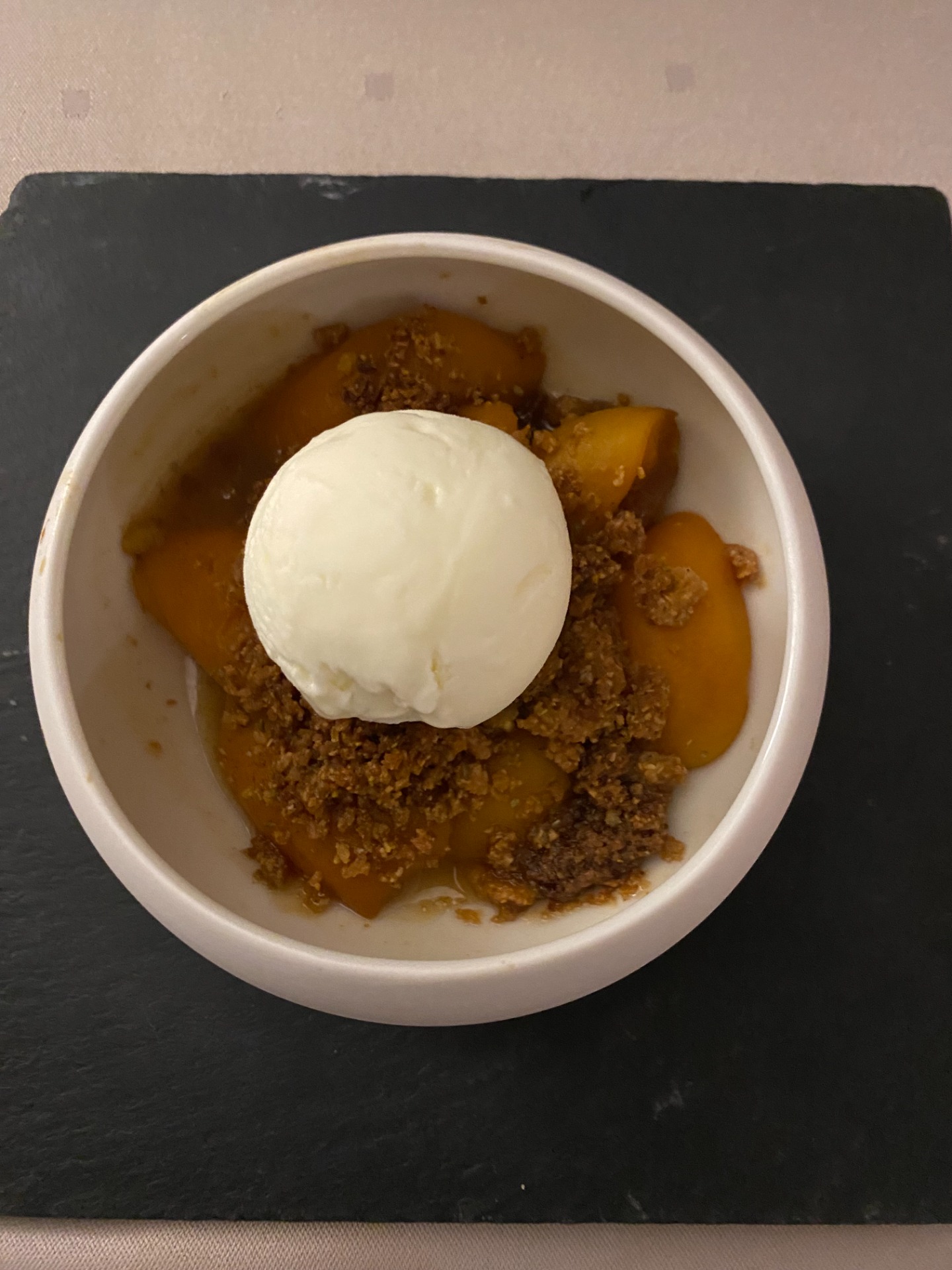 Bol blanc rempli de sauce orange, morceaux de légumes, et une boule de fromage blanc au centre.